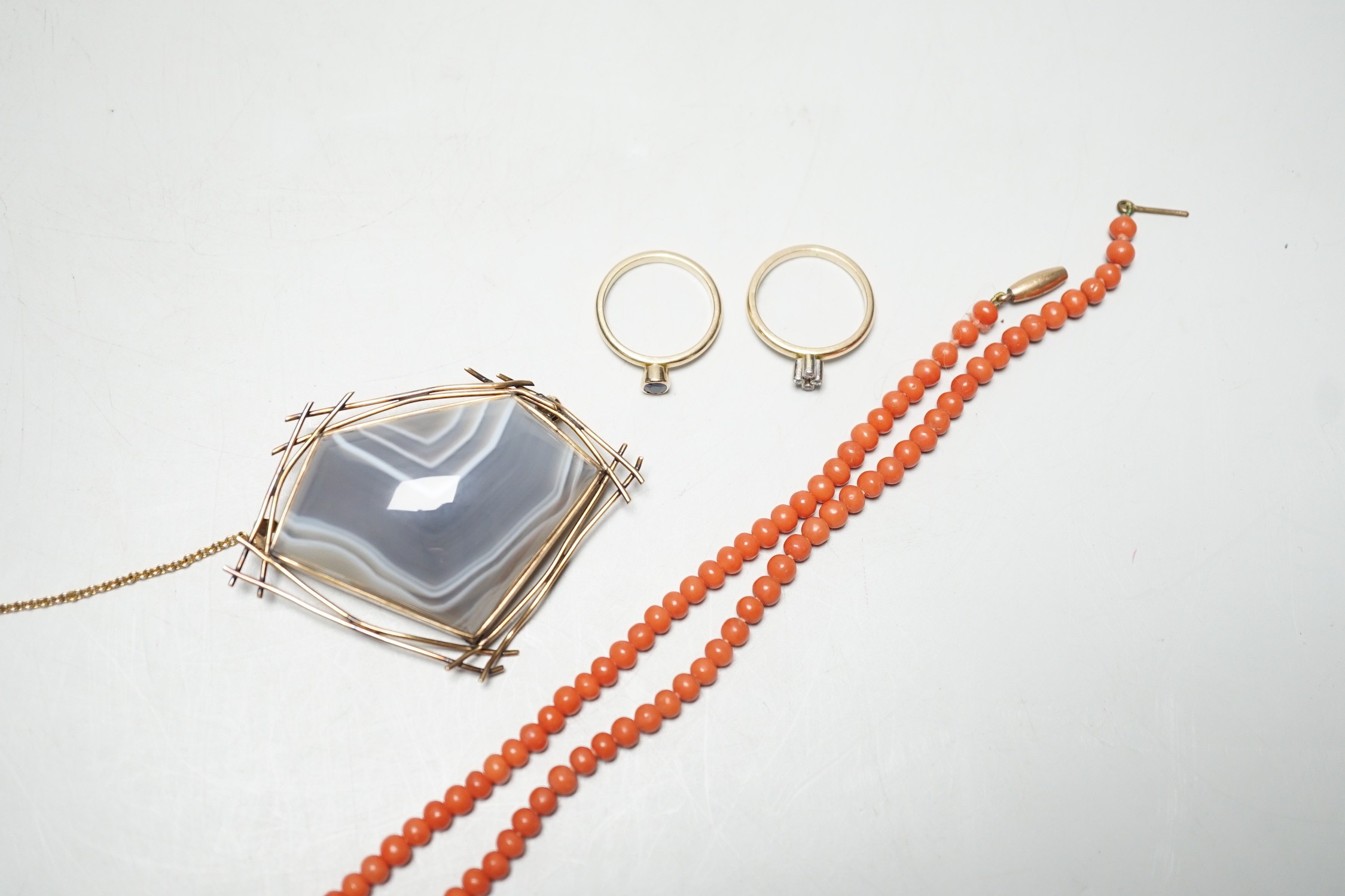 A 9ct mounted banded agate shaped pentagonal brooch, width 60mm, gross weight 27.6 grams a yellow metal and four stone diamond chip set ring, a similar collet set solitaire sapphire ring, gross weight 5.1 grams and a cor